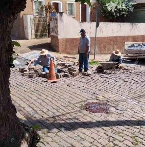 Servidores pblicos do manuteno a trecho com paraleleppedos soltos na praa da Catedral